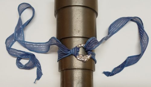 Judy Larson's Ribbon Wrapped Bracelet tips - , Wire Jewelry Design, Design, A silver heart-shaped charm is tied onto a metallic cylinder with a light blue ribbon